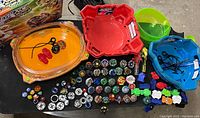 Full display of Beyblade collection with 4 arenas, many tops, launchers, and accessories arranged on a table