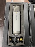 Rode NT1 microphone inside a foam-padded compartment of a hard case, showing microphone clip below it.