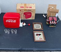 Full view of lot items including dispenser, box, glasses, two framed mirrors and stained glass light