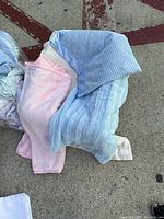 Pink and blue textured blankets with striped patterns visible, showing soft textile materials.