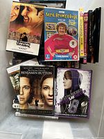 Various DVD cases stacked together showing front covers of movies, TV shows, and music DVDs.