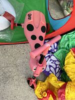 Pink and black ladybug-themed Scuttle Bug ride-on showing seat and front wheels.