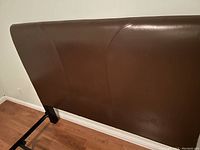 Close-up of brown leather headboard showing texture and seams
