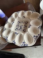 Top view of the ceramic deviled eggs tray showing 12 egg compartments and blue floral pattern on the ridged edge.