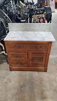 Front view of the antique side hutch showing the marble top and backsplash with all drawers and the cabinet door closed.