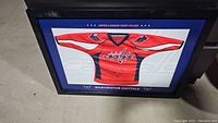Framed mini jersey artwork showing red Capitals jersey with signatures and text indicating season ticket holder.