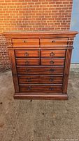 Front full view of the 7-drawer wooden chest showing drawer arrangement and metal pulls