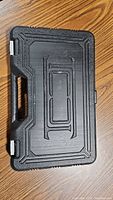 Top view of black textured plastic carrying case with embossed logo and handle, closed.