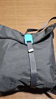 Black storage bag for Jeep cab cover with adjustable black strap and blue buckle, made of nylon or polyester.