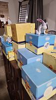 Stacked Royal Doulton Winnie the Pooh collection boxes featuring figurines on top, including Eeyore holding a gold heart.