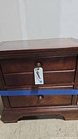 Front view of the Stanley side table showing the two drawers, one with keyhole and round metal pull handles.