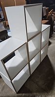7 white large storage cubes arranged in a staggered stack.
