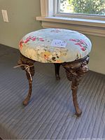 Top view showing round floral fabric seat, pastel green background with red, pink and white flowers