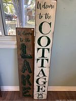 Both signs standing side by side, showing the full length and front painted surfaces.