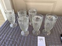 Seven clear iris pattern sundae glasses arranged in two rows