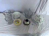 Full view of all items on white cloth, showing covered dishes, spooners, hair receivers and soap dish