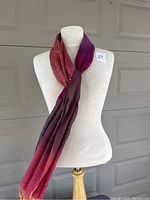 Full view of mannequin torso with scarf draped and tied around the neck.