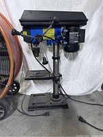 Front and side views of the Mastercraft drill press showing overall condition and features including the worktable, motor, and adjustment handles.