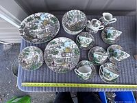Top overview photo showing full dish set arranged on a padded surface, including plates, bowls, cups, saucers, cream and sugar bowl.