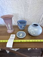 All four Wedgwood Jasperware pieces displayed on a table with measuring tape showing dimensions.