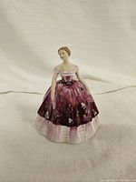 Front view of Coalport Kimberley figurine showing detailed pink and purple dress with butterfly motifs.