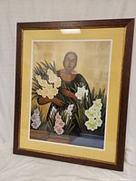 Front view of the framed art print showing the woman holding flowers, matting, and wooden frame.