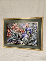 Frontal photo of the floral print showing red and purple flowers, green matting, and gold frame.