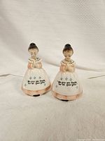 Front view of the salt and pepper shakers showing two girls in aprons with thank you message on the front