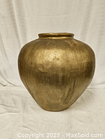 Front and side view of a large gold vase with a rounded, bulbous shape and a narrow opening on top.