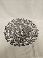 Top view of the black metal spiral decorative bowl showing the intricate spiral wire pattern forming the bowl shape.
