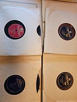 Four vintage records in paper sleeves showing labels from Columbia, Crown, and Apex records.