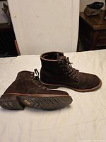 Side view of brown suede boots showing profile and sole condition.