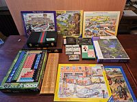 Lot overall layout showing puzzles, backgammon sets, cribbage boards, playing cards on tabletop