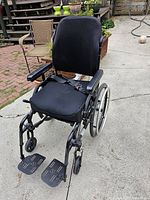 Front angle view showing padded seat, footrests extended and seat belt