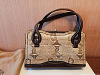 Front view showing snakeskin pattern and leather trim with handles folded back