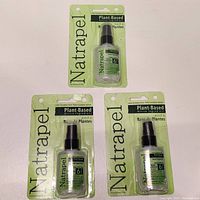 Three packages of Natrapel plant-based insect repellent sprays in green packaging, each in a plastic blister pack with black pump spray bottles inside.