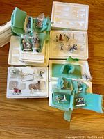 Overview of multiple Hawthorne Village Rudolph figurines and accessories in original styrofoam packaging with protective foam and sealed plastic bags.