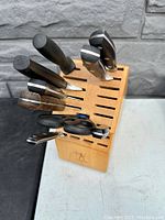 Front view of J.A. Henckels wooden cutting tool block filled with various cutting tools including knives and scissors.