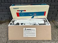 Vintage Tasco telescope in original box with styrofoam insert showing telescope tube and accessories