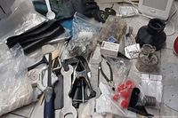 Set of various dental equipment, hand tools, and accessories including polishing wheels, wrenches, clamps, drill bits and Verilux machine parts spread on tabletop.