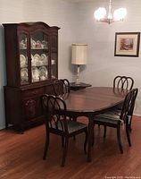 Photo showing the entire dining room set with china cabinet, dining table and chairs, corner table, and marble lamp.