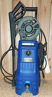 Front view of blue Simoniz 1900 PSI pressure washer with attached black spray gun handle and hose reel on top.