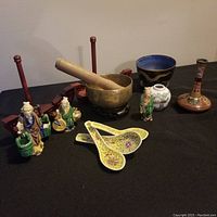 Full view of lot showing figurines, spoons, brass singing bowl with striker, and vases.