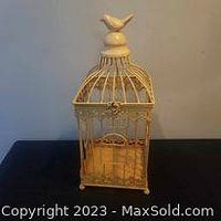 Front view of vintage decorative bird cage showing rectangular shape and bird finial topper