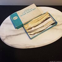 6-piece steak knife set in original box on marble cutting board from top view showing knife handles and box