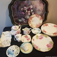 Lot of assorted vintage Paragon and Aynsley fine bone china pieces with floral patterns and gold trim, arranged with a floral painted tin tray
