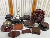 Main image showing the collection of wooden stands, metal easel, metal bowl, and ceramic dish arranged on a table.