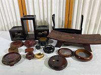 Full view of collection on white surface showing multiple wooden stands and display items with some dust present.