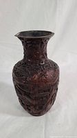 Full view of dark red cinnabar vase with intricate carved details.