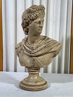 Front view showing the full 14-inch Roman bust with draped clothing and pedestal base, displaying aged patina and weathering details.